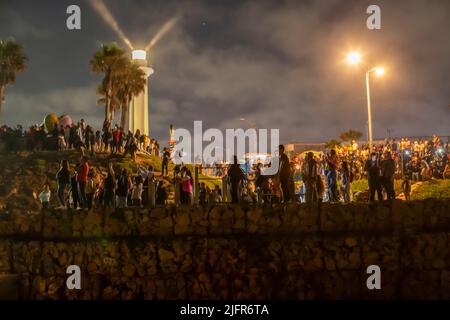 Tijuana, Mexiko. 04.. Juli 2022. Hunderte von Menschen beobachten vom Grenzzaun in Playas de Tijuana, Mexiko, wie in der Bucht von San Diego, Kalifornien, ein Feuerwerk zum US-Unabhängigkeitstag gestartet wurde. An der Veranstaltung nahmen zahlreiche Deportierte aus den Vereinigten Staaten Teil. Außerdem kamen ein Dutzend Migranten verschiedener Nationalitäten an die Wand, um weniger Todesfälle und Einwanderungsreformen in den Vereinigten Staaten zu fordern. Quelle: Omar Martinez/dpa/Alamy Live News Stockfoto