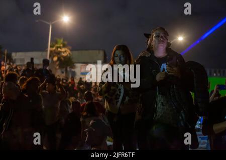 Tijuana, Mexiko. 04.. Juli 2022. Hunderte von Menschen beobachten vom Grenzzaun in Playas de Tijuana, Mexiko, wie in der Bucht von San Diego, Kalifornien, ein Feuerwerk zum US-Unabhängigkeitstag gestartet wurde. An der Veranstaltung nahmen zahlreiche Deportierte aus den Vereinigten Staaten Teil. Außerdem kamen ein Dutzend Migranten verschiedener Nationalitäten an die Wand, um weniger Todesfälle und Einwanderungsreformen in den Vereinigten Staaten zu fordern. Quelle: Omar Martinez/dpa/Alamy Live News Stockfoto