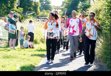 Der Schlagstock-Träger Julian Stafford-Wood trägt die Queen's Baton entlang des Kennet- und Avon-Kanals in der Nähe der Stadt Devizes in Wiltshire, während er die 2.500 Meilen lange letzte Etappe seiner Reise zu den Commonwealth Games 2022 in Birmingham fortsetzt. Der Stab enthält die Botschaft der Königin und wurde durch 72 Nationen und Gebiete getragen. Tausende von Batonbearern wechseln sich ab, um den Stab vor der Eröffnungszeremonie am 28. Juli auf der Reise durch Großbritannien zu tragen. Bilddatum: Dienstag, 5. Juli 2022. Stockfoto