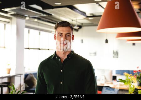 Porträt eines selbstbewussten jungen kaukasischen Geschäftsmannes im kreativen Büro Stockfoto
