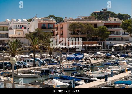 Cala Ratjada, Mallorca, Spanien; 25.. Juni 2022: Hafen im Zentrum von Cala Ratjada mit Wohngebäuden und einer Promenade Stockfoto