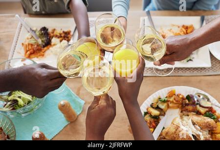 Im Familienleben ist Liebe das Öl, das die Reibung lindert. Aufnahme einer nicht erkennbaren Familie beim Toasten während des Mittagessens zu Hause. Stockfoto