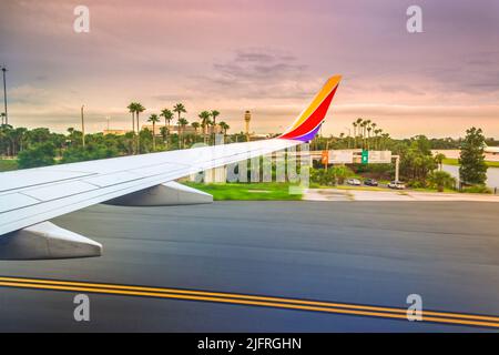 Faszinierender Sonnenuntergang am Orlando International Airport, der durch das Fenster eines Southwest Airlines 737 nach der Landung gesehen wird Stockfoto