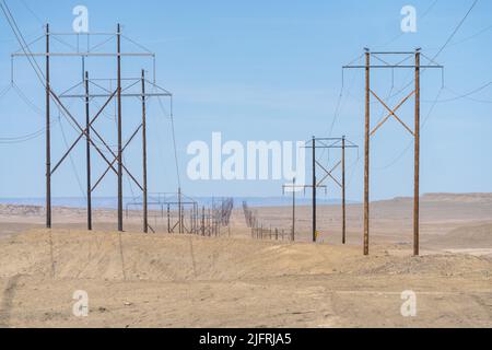 Hölzerne Stromübertragungstürme erstrecken sich über die karge Wüste in Utah. Stockfoto