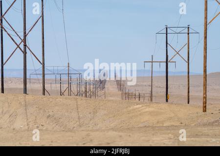 Hölzerne Stromübertragungstürme erstrecken sich über die karge Wüste in Utah. Stockfoto