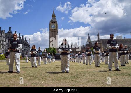 London, Großbritannien. 3.. Juli 2022. Tierrechtsaktivisten der Organisation Wir stehen für die Tiere veranstalteten auf dem Parliament Square eine Gedenkstätte für Milliarden von Tieren, die von Menschen für Nahrung und Kleidung, Experimente, Unterhaltung und Jagd missbraucht, ausgebeutet und getötet wurden. Einige Aktivisten hielten echte tote Tiere fest, die an natürlichen Ursachen starben, während andere Fotos von den verschiedenen Arten hielten, die routinemäßig von Menschen missbraucht werden. Stockfoto