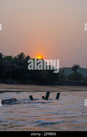 Dunkles Holz an der Meereslandschaft. Sonne im Back.om Strand, in Karnataka Stockfoto