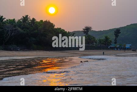 Sonne am Strand von om.goldenes Licht, das sich auf Sand spiegelt.Sonnenaufgang am Strand von om in gokarna Karnataka Stockfoto