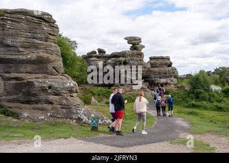 Menschen genießen einen Tag in Brimham Rocks, natürlichen Felsformationen in der Nähe von Harrogate in North Yorkshire, Großbritannien. Stockfoto
