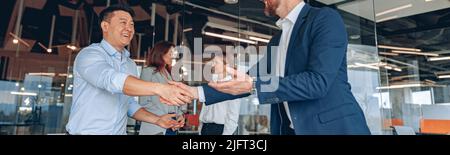 Kollegen schütteln im modernen Büro während eines Teamwork-Meetings die Hände Stockfoto