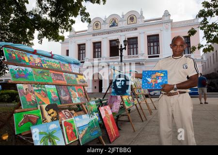 Kuba, Cienfuegos. Im Parque Jose Marti versuchen Maler, ihre Werke vor dem Teatro Tomas Terry an Touristen zu verkaufen. Stockfoto