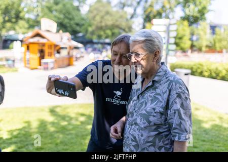 Karlsruhe, Deutschland. 05.. Juli 2022. TV-Moderator Frank Elstner macht ein Selfie mit einem Fan. Anfang November war das Comeback der TV-Show 'Wetten, dass.' zu sehen. Die Moderatoren Thomas Gottschalk und Frank Elstner hatten darin als Wette eine Führung mit Schulklassen im Karlsruher Zoo versprochen und machten sich daran heute gut. Quelle: Philipp von Ditfurth/dpa/Alamy Live News Stockfoto