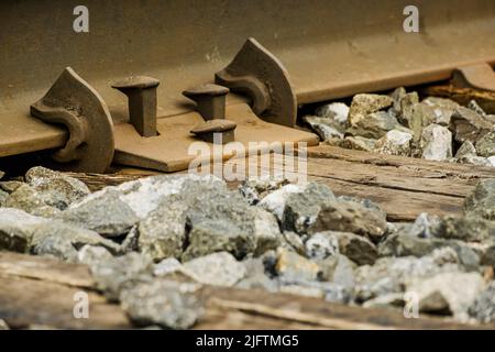 Schrauben auf einer Eisenbahnstrecke, die von Pendlern- und Güterzügen in einer Vorstadt verwendet wird. Stockfoto