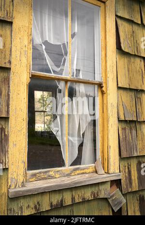 Verwittertes Fenster. Holzfenster auf einem alten verwitterten verlassenen Gebäude. Stockfoto