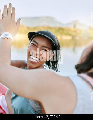 Eine fröhliche Frau ist positiv und motivierend, während sie mit ihrem Partner beim Kajakfahren und bei der Wasseraktivität auf einem See ist. Nahaufnahme von zwei aktiven Freunden Stockfoto