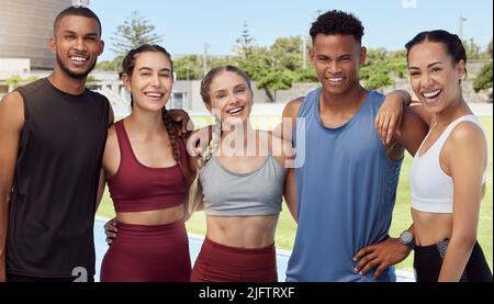Portrait einer Gruppe von Athleten, die nach dem Training zusammen stehen und lächeln. Jung, glücklich, fit, aktive Sportmannschaften im Trainingssport Stockfoto