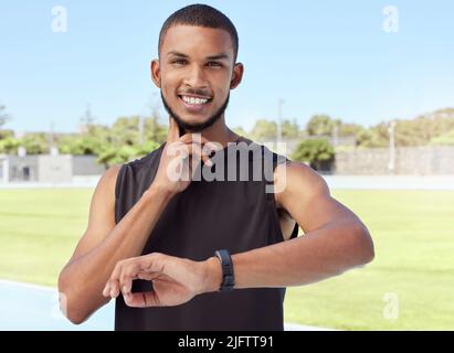 Junger Sportler, der einen Fitness-Tracker verwendet, um den Fortschritt, die Herzfrequenz und die verbrannten Kalorien während eines Trainings zu überwachen. Porträt eines Sportlers, der seinen Puls überprüft Stockfoto