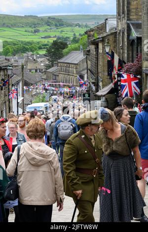 Haworth 1940er's Re-enactment Event (re-enactors on busy crowded Main Street decorated in Union Jacks, popular day-out) - West Yorkshire, England, UK. Stockfoto