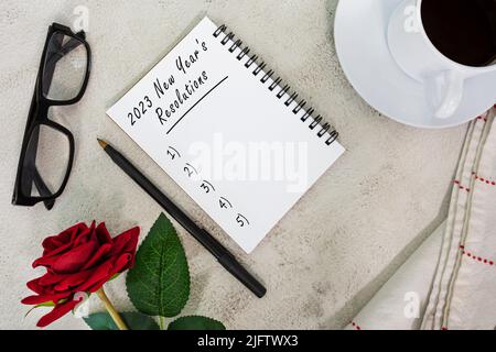 2023 Neujahrsvorsätze geschrieben auf einem Notizbuch auf einem weißen Marmortisch. Stockfoto