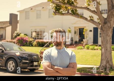 Glad Immobilienhändler im Freien am Haus und Auto Stockfoto