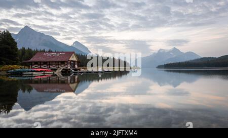 Friedlicher Sonnenaufgang am Ufer des noch alpinen Sees mit Bootshaus, Jasper NP, Kanada Stockfoto