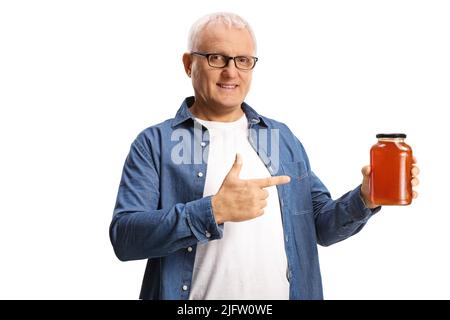 Reifer Mann hält ein Glas Honig und zeigt isoliert auf weißem Hintergrund Stockfoto