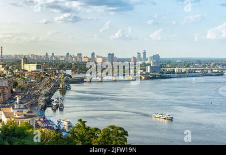 Stadtbild von Kiew, Ukraine. Blick auf Podol und Dnipro am Abend in Kiew, Ukraine. Moderne Gebäude und Autoverkehr am Sommertag. Stockfoto