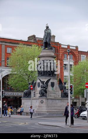 Vertikale Aufnahme des O'Connell Monument vom Bildhauer John Henry Foley in Dublin. Schwarze Statue auf hellgrauem Sockel mit Figuren von Engeln, Frauen und Männern. Stockfoto