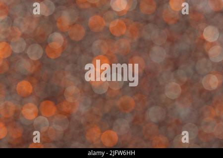 Nahaufnahme des orangefarbenen Glitter-Hintergrunds mit Partikeln. Stockfoto
