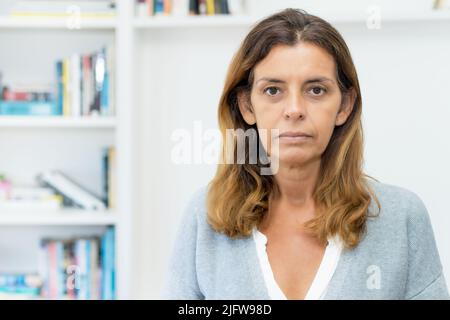 Porträt einer traurigen und einsamen erwachsenen Frau zuhause Stockfoto