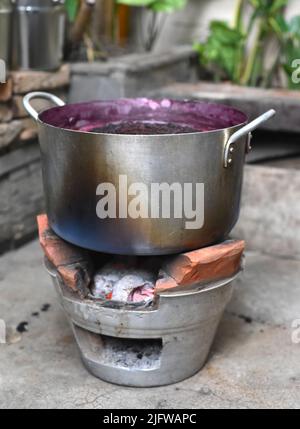 Kochender Maulbeermarmelade in einem Metallkochtopan auf traditionellem vietnamesischem offenem Feuer Stockfoto