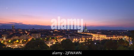 Turin, Italien. Panoramablick auf die Stadt beleuchtet am Abend nach Sonnenuntergang. Skyline mit dem Maulwurf am Abend. Banner-Kopfzeile Horizontal. Stockfoto