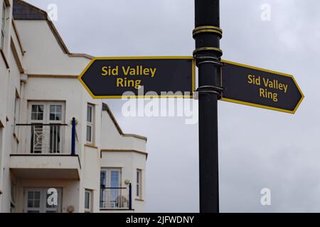Ein Schild mit goldenem Schriftzug auf schwarzem Hintergrund in Sidmouth, Devon, das auf die Route des Sid Valley Ring Walking Route hinweist. Der 13 Meilen Weg war Stockfoto