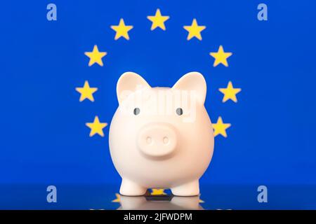 Keramikschweinebank mit Flaggenanstrich, Europäische Union. Das Problem liegt in der Wirtschaft. Die Wirtschaftskrise. Sparkonzept. Stockfoto