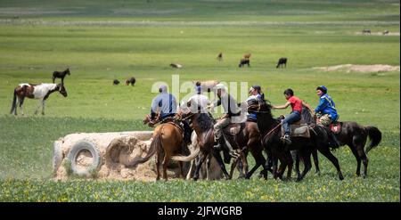 Männer spielen auf einem Feld in Kirgisistan eine Partie Kok Boru oder totes Ziegenpolo. Stockfoto