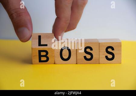 Hand drehen Holzwürfel zu VERLUST BOSS. Speicherplatz kopieren. Schlechtes Geschäftsführungskonzept. Stockfoto