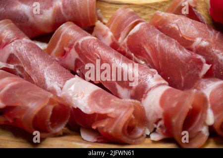 Schinken, in Scheiben geschnittenes Fleisch auf einem Holztablett Stockfoto