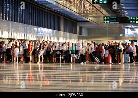 Touristen stehen mit Gepäck in der Schlange am Flughafen Dalaman. Passagiere während des Check-ins, Reisen im Sommer Stockfoto