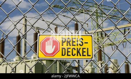 Deutsches Infotafel Preisdeckel (Preisobergrenze) mit Umspannwerk im Hintergrund Stockfoto