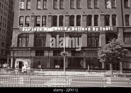 New York, NY, USA - 26. Juni 2022: Banner wird vor Beginn der Gay Pride Parade am Bürogebäude angebracht Stockfoto