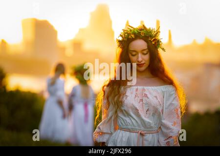 London, Großbritannien. 5.. Juli 2022. Die britisch-ukrainische Alisa (rechts) feiert Ivana-Kupala im Greenwich Park. Der Ivan Kupala Tag, auch bekannt als Ivana-Kupala oder Kupala Nacht, ist ein traditionelles heidnisches Feiertag Volksfest in den ostslawischen Kulturen. Mädchen kreieren und tragen Blumenkränze und führen verschiedene Rituale durch. Zunächst war Ivana-Kupala ein heidnischer Fruchtbarkeitsritus, der auch mit der Feier der Sommersonnenwende verbunden war, wenn die Nächte die kürzesten sind. Nach dem Eintreffen des Christentums waren die Riten mit dem christlichen Fest der Geburt Johannes des Täufers verflochten. Kredit: Guy Corbishley/Alamy Liv Stockfoto