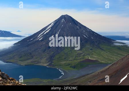 Der Cleveland Vulkan vom westlichen Ende des Tana Vulkans in Alaska aus gesehen. Mount Cleveland, auch bekannt als Cleveland Volcano, ist ein fast symmetrischer Stratovulkan am westlichen Ende der Chuginadak Island, die zu den Inseln der vier Berge westlich der Umnak Island auf den Fox Islands der Aleutischen Inseln von Alaska gehört. Mt. Cleveland ist 5675ft (1730m) hoch und einer der aktivsten der 75 oder mehr Vulkane im größeren Aleutenbogen. Kredit: J.Lyons, USGS. Stockfoto