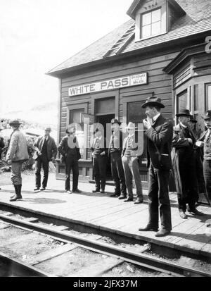 Historisches Bild. Klondike Goldrush, 1900. Herren und Prospektoren stehen am White Pass & Yukon Railroad Station in Alaska. Die Station war ein Hauptpunkt für die Prospektoren, um zu den Goldfeldern von Alaska und Yukon zu fahren, die, ohne sie zu wissen, bereits die meisten guten Klondike-Behauptungen abgesteckt hatten.der Herr in weißem Hut ist Sidney Paige, Ein Geologe des US Geological Survey, der auch das Gebiet erkundeten und die Mineralien für die USGS inventarisierten. Kredit: USGS. Stockfoto