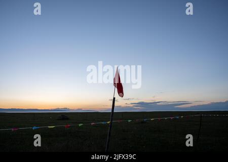 Eine Grenze am Strand durch verschiedene farbige Fahnen getrennt eine große rote Flagge in der Mitte gepflanzt Stockfoto