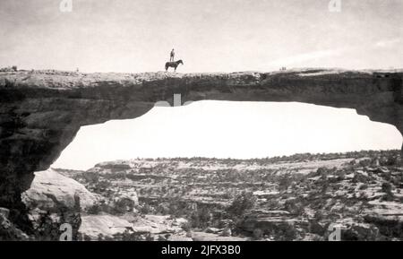 Historisches Bild. Vertrauen. Dan Perkins von der US Geological Survey steht auf seinem Pferd 'Cap' auf der Owachomo Bridge, Natural Bridges National Monument, Utah, USA.circa 1925. Kredit: W.T.Lee / USGS Stockfoto