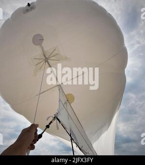 Als Alternative zu unbemannten Luftbildsystemen (UAS) verwenden Wissenschaftler in Großbritannien hergestellte Helikites, die mit Kameras ausgestattet sind, um Bilder der Landschaft zu sammeln. Hier bereitet sich ein US Geological Survey Forscher darauf vor, einen Helikit an einem Strand im Pea Island National Wildlife Refuge am Outer Banks of North Carolina, USA, zu schleppen. Kredit: J.R. over/USGS Stockfoto