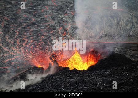 Foto des Einsturms vom westlichen Schlot im Halema'uma'U Krater, auf dem Gipfel des K?lauea, Hawaii, USA. Der Wasserspritzer aus dem Brunnen bildet einen hufeisenförmigen Kegel um den Schlot herum, wobei Lava am Fuß in den See fließt. Dieses Foto wurde am 5. Oktober 2021 vom westlichen Krater aufgenommen. Kredit: N.Deligne/USGS Stockfoto