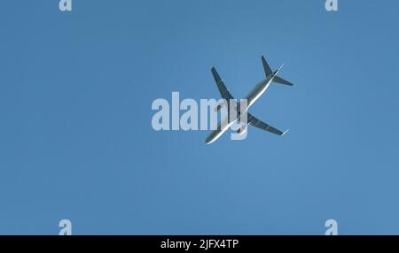 Warschau, Polen - 26. Juni 2022: Passagierflugzeug über blauem Himmel, Blick vom Boden. Reisen Sie mit dem Flugzeug. Stockfoto