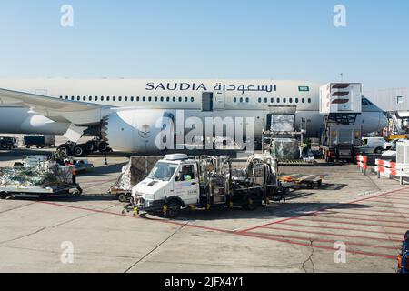 Saudia Aircraft, Boeing Dreamliner 787-900, umgeben von Bodenausrüstung. Saudia, früher bekannt als Saudi Arabian Airlines, ist die Flaggenträger von S Stockfoto