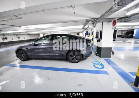 Parken unter der Madeleine-Kirche, mit eingesteckten Tesla-Autos, die am 24. April 2022 in Paris, Frankreich, aufgeladen werden. Eine halbe Tausend Ladestationen Stockfoto